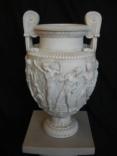 a white vase sitting on top of a pedestal