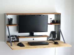 a flat screen tv sitting on top of a wooden shelf next to a keyboard and mouse