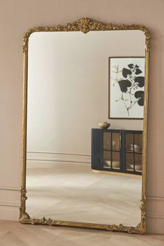 a large mirror sitting on top of a wooden floor