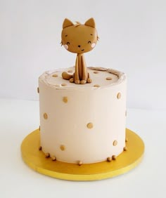 a cake decorated with a cat sitting on top of it's base and polka dots