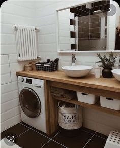 a washer and dryer in a bathroom next to a sink with a mirror above it