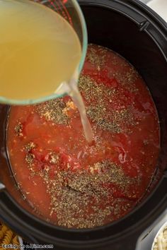 the sauce is being poured into the slow cooker