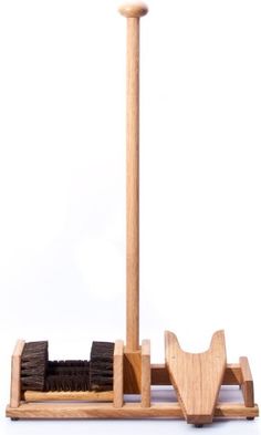 a wooden stand with a broom and duster on it, against a white background