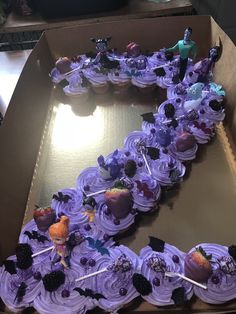 a box filled with cupcakes covered in purple frosting