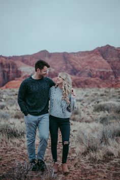 a man and woman standing in the desert