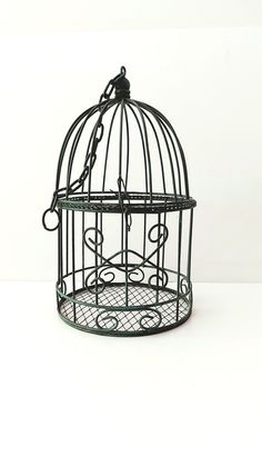 a black bird cage sitting on top of a white table