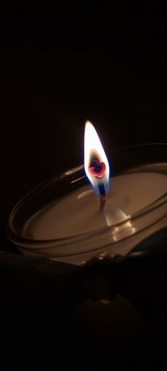 a candle is lit in the dark on a plate