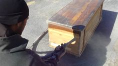 a man holding an object in front of a wooden box