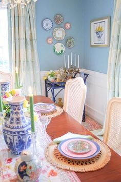 a dining room table with plates and candles on it