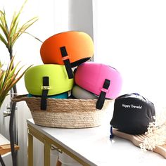 a basket filled with lots of different colored items on top of a table next to a potted plant