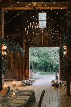 the inside of a barn with tables and chairs set up for an outdoor dinner party