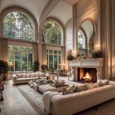 an elegant living room with high ceilings and large windows, along with a fireplace in the center