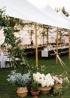 an outdoor tent set up with flowers and greenery