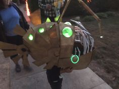 a person is holding a paper bag shaped like a fish with green lights on it