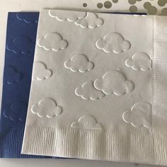 two napkins with white clouds on them sitting next to each other in front of polka dots