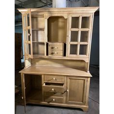 a wooden hutch with glass doors and drawers