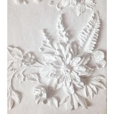 an intricately designed wall panel with flowers and leaves on it's side, in white