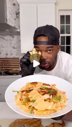 a man holding a plate of food in front of his face and looking at the camera