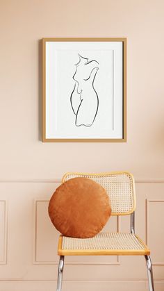 a chair in front of a wall with a drawing on it and a framed nude woman