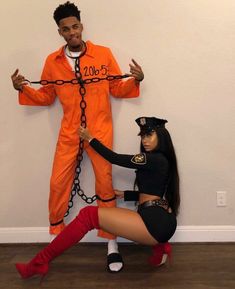 a man and woman in orange prison uniforms are chained up to each other with chains