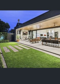 an outdoor living area with grass and patio furniture