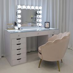 a white desk with a chair and a lighted mirror