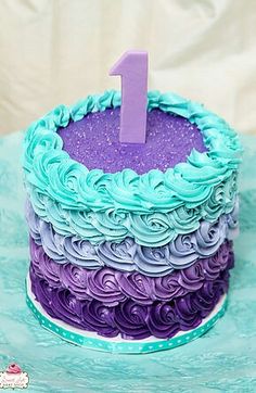 a purple and blue cake with the number one on it