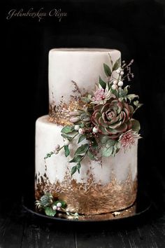 a white and gold wedding cake with succulents