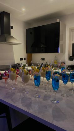 a table topped with lots of glasses filled with different colored drinks