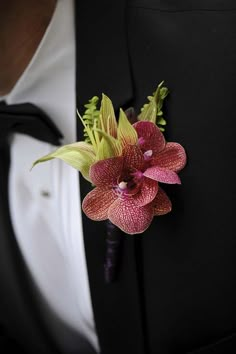 a man in a tuxedo wearing a boutonniere with flowers on it