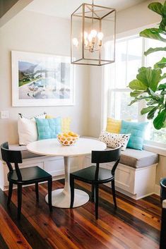 a white table with two chairs and a bench in front of a potted plant