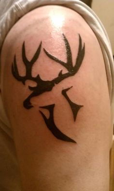 a man's arm with a deer tattoo on the back of his shoulder,