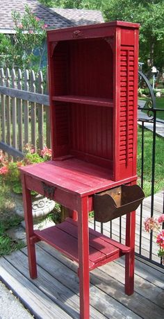 an old fashioned red cabinet is sitting on the porch