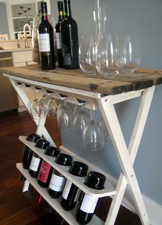 wine glasses and bottles are sitting on a shelf