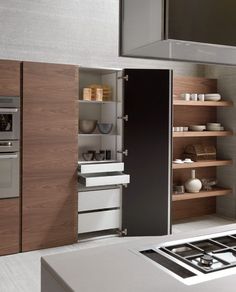 a modern kitchen with an oven, stove and cabinets in the corner that are built into the wall