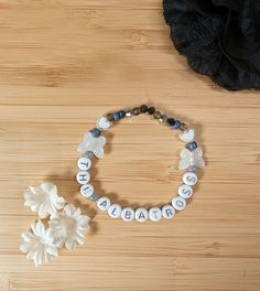 a bracelet with the word diabet written on it and two white flowers sitting next to it