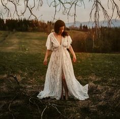 a woman wearing a white dress standing in the grass