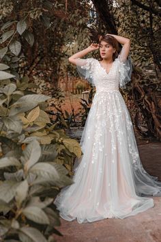 a woman in a wedding dress posing for the camera with her hands on her head