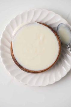 a bowl of milk and a spoon on a plate