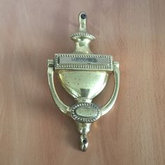 a silver trophy hanging on a wooden wall with a metal hook attached to it's side