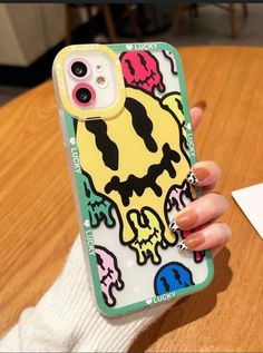 a person holding an iphone case with skulls on it