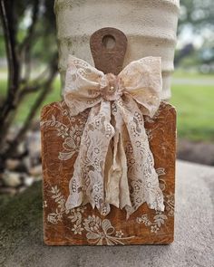 a wooden block with a bow and lace on it