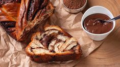 two slices of cinnamon swirl bread on top of wax paper next to some dipping sauces