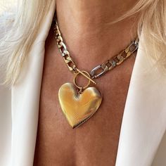 "This oversized gold heart pendant hangs from a statement figaro link chain with a toggle clasp closure! This chunky necklace is a must-have whether you plan to layer or style it solo.  Details * Stainless steel chain 11.5mm mixed gold and silver links. Water Resistant, Tarnish Free, Hypoallergenic * Chain Style: Figaro * Chain thickness: 2.5mm   * Different Chain lengths, from 16\" to 22\" inches long including the toggle closure. Choose the length from the dropdown menu. * Gold-plated brass he Luxury Artisan Heart Necklace, Metal Heart Necklace With Chunky Chain, Chunky Heart Pendant Jewelry Gift, Gold Chunky Heart-shaped Jewelry, Chunky Heart-shaped Gold Jewelry, Chunky Heart Shaped Gold Jewelry, Trendy Heart Necklace With Chunky Chain For Valentine's Day, Chunky Heart-shaped Gold Necklace, Heart-shaped Gold Chain Necklace