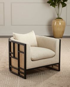 a white chair sitting on top of a wooden floor next to a potted plant