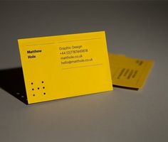 a yellow business card sitting on top of a table