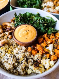 a white bowl filled with rice and vegetables next to other bowls full of sauces