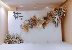 a white backdrop with flowers on it and the words glamour station written in cursive writing