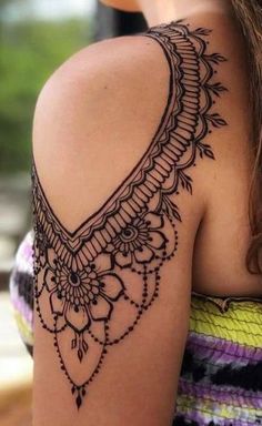 the back of a woman's shoulder with an intricate design on it