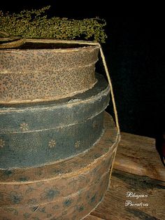 a stack of four old fashioned hats on top of a wooden table